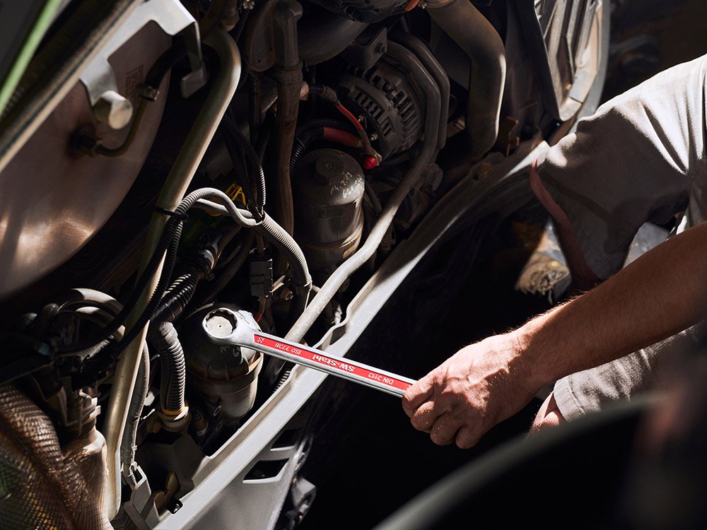 Service und Reparaturen an Landmaschinen Mechaniker führt Reparaturarbeiten an einer modernen Landmaschine durch